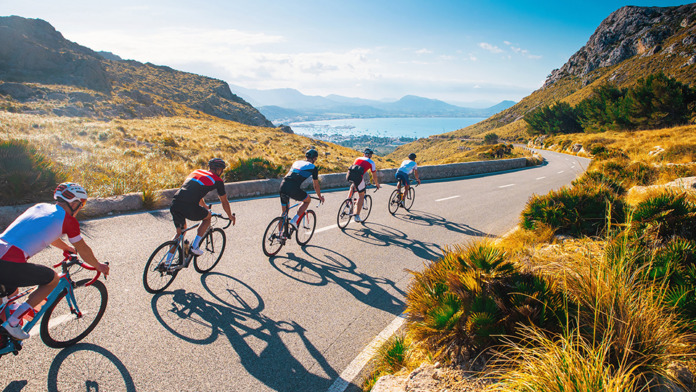 Group of cyclist ride together on road bicycles in beautiful nat
